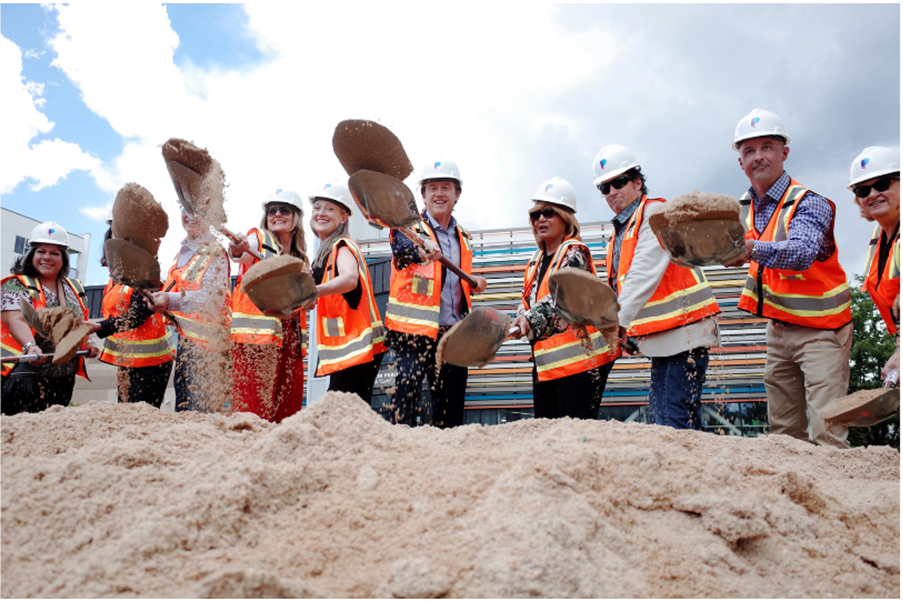 Groundbreaking ceremony for The Irving housing complex in Denver, featuring shovels raising sand.