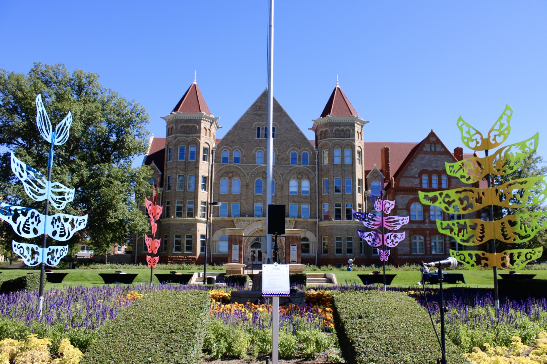 4 sculptures made up of colorful wings surround the flag pole in front of St. Elizabeth's School on Mosaic Community Campus