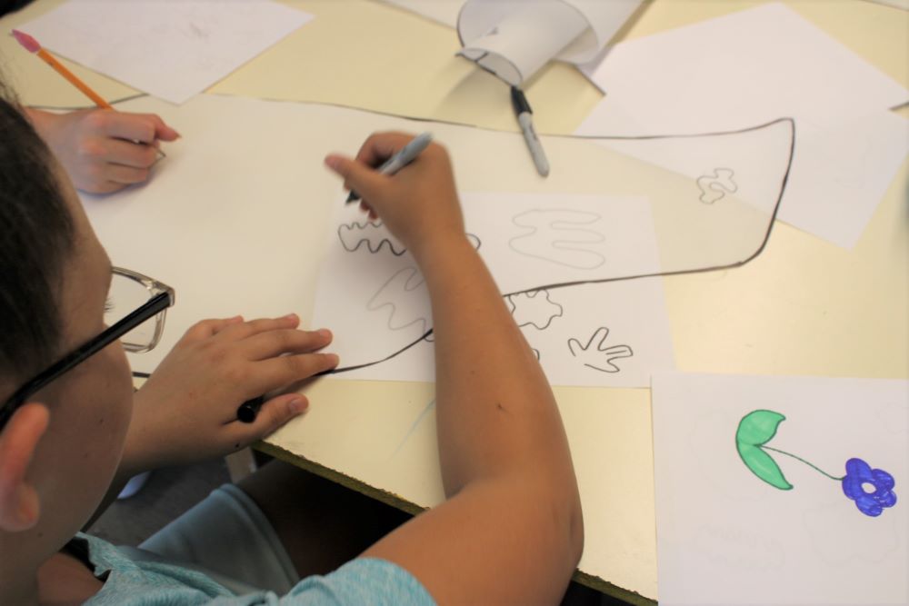 A St. Elizabeth's student traces shapes onto a paper wing