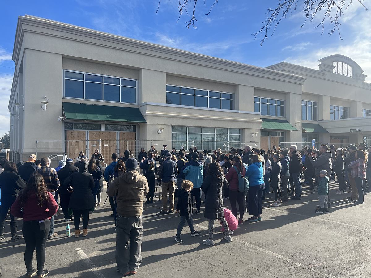 a large group of people standing in front of a hotel building