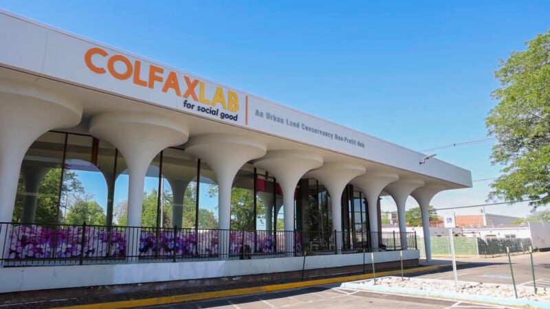 White one-story building with large windows and funnel-like columns. Sign: COLFAXLAB