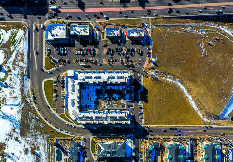 Aerial view of empty lot next to building complex