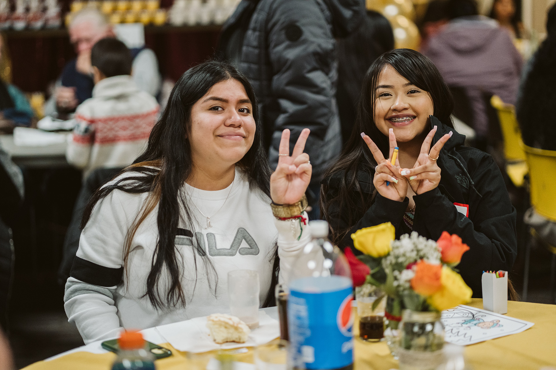 Two young women making a peace sign with hands