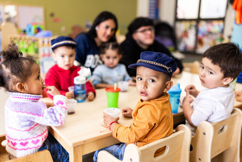 preschool children sitting at a table in a school