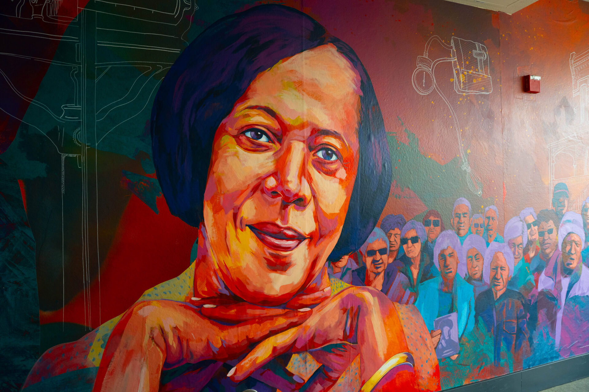 a mural of a woman with a group of people beside her