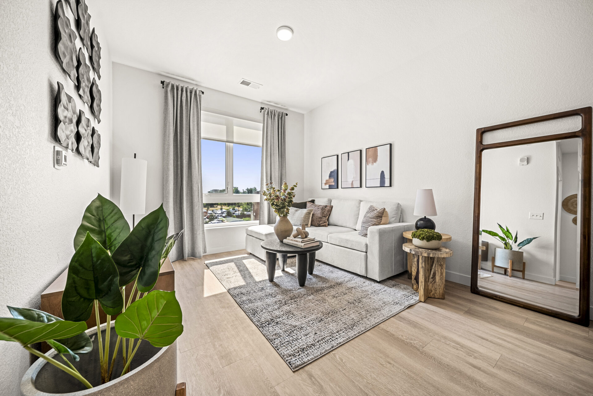 a living room with a sunny window, couch and other furniture