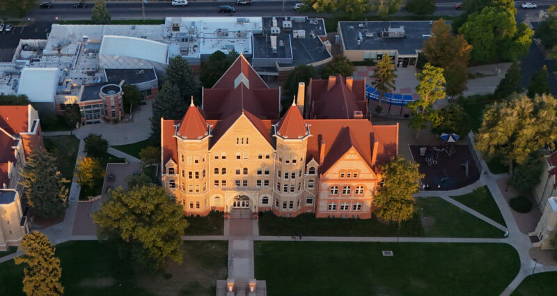 a photo of a historic school building with a red roof